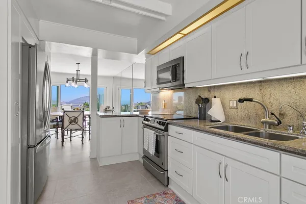 a kitchen with a sink cabinets and stainless steel appliances