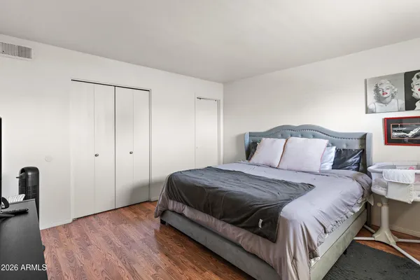 a bedroom with a bed and wooden floor