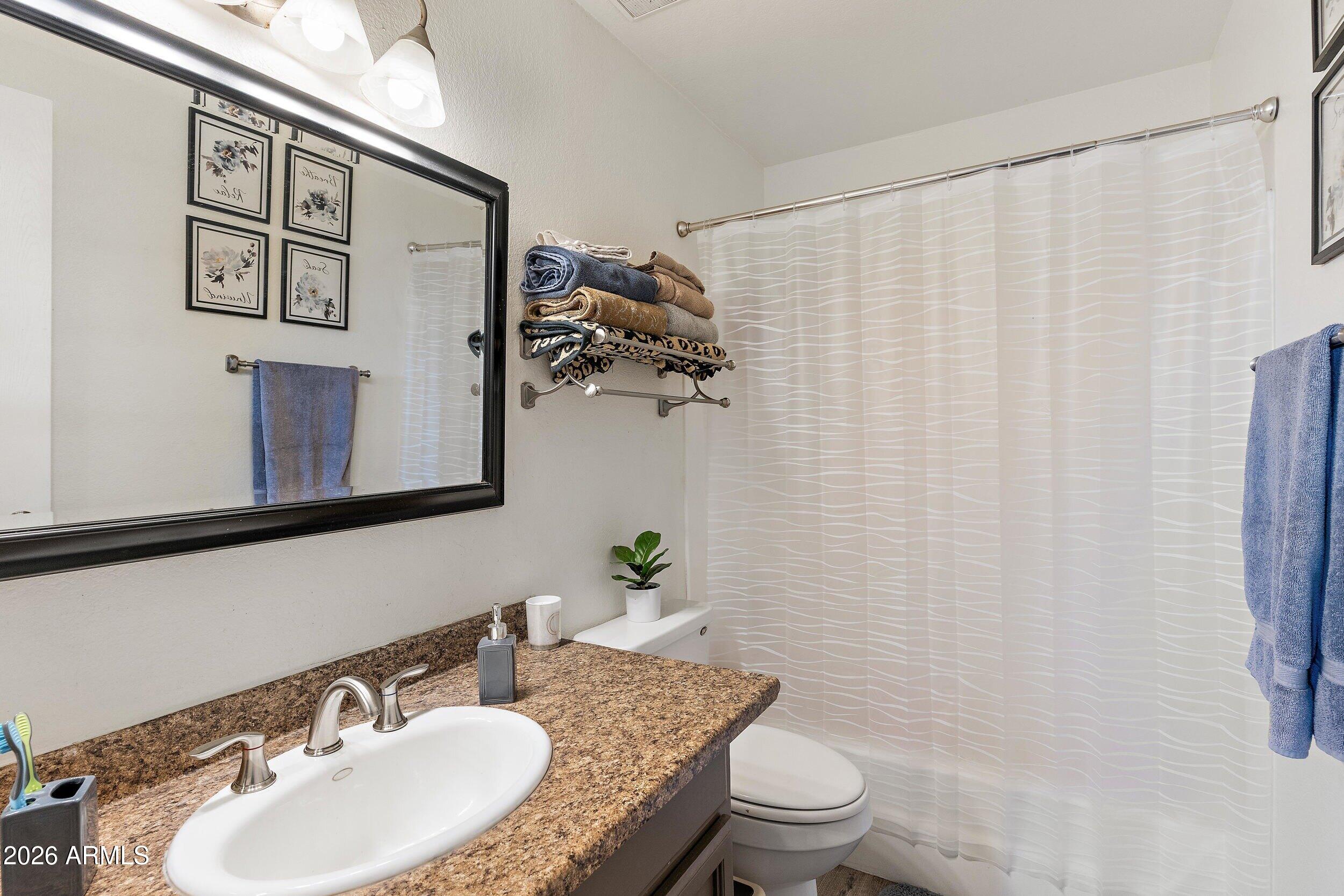 222 West Brown Road, Unit 57 Mesa, AZ 85201 - Photo 18 of 21 a bathroom with a granite countertop sink and a mirror