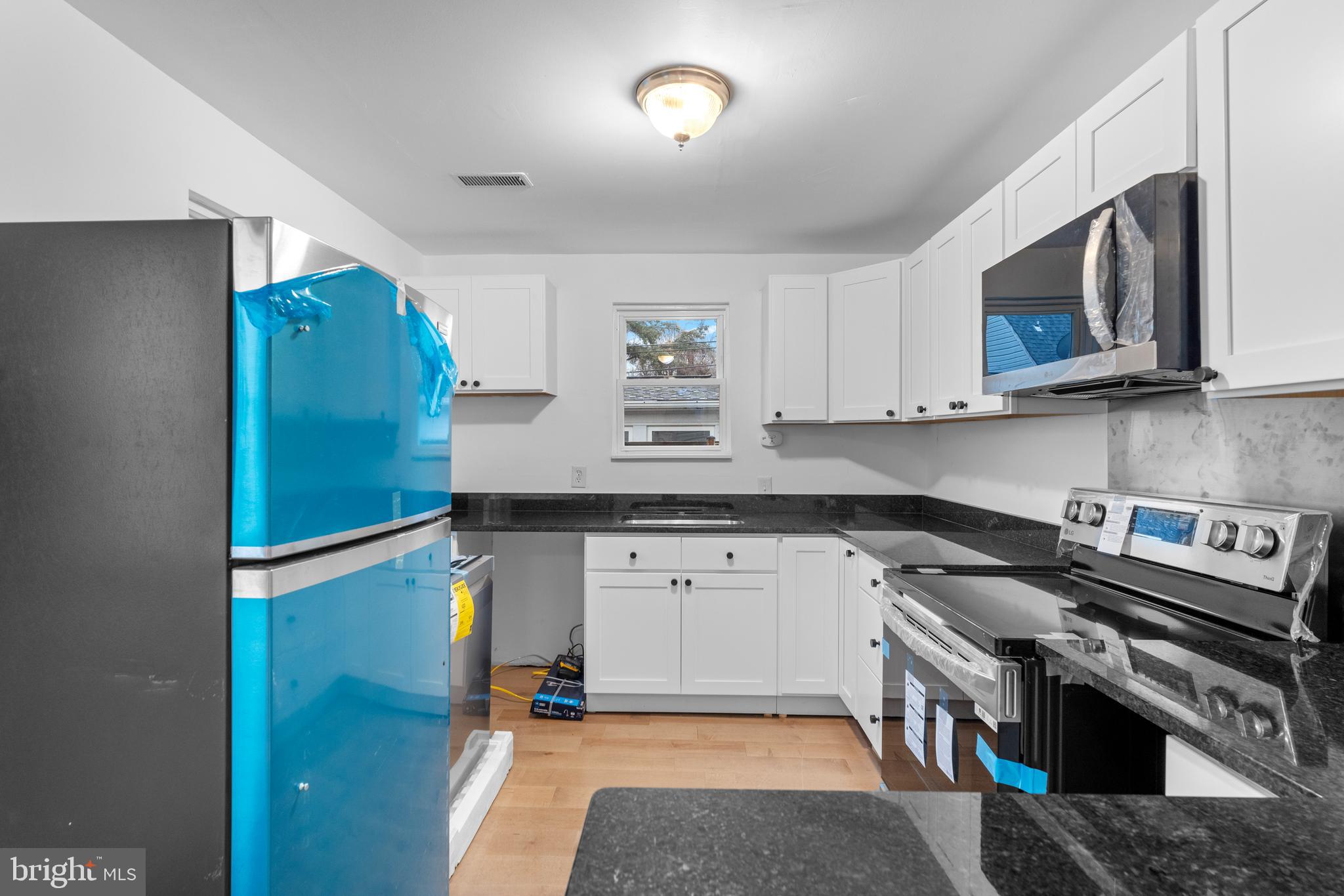 1504 Taylor Avenue, Unit B Parkville, MD 21234 - Photo 6 of 20 a kitchen with stainless steel appliances granite countertop a refrigerator a stove a sink and a microwave