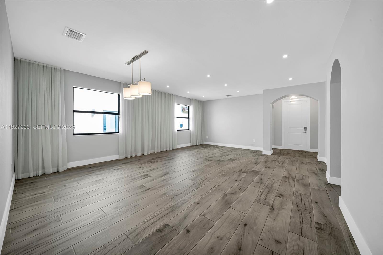 11448 Southwest 151st Path Miami, FL 33196 - Photo 11 of 35 an empty room with wooden floor and windows