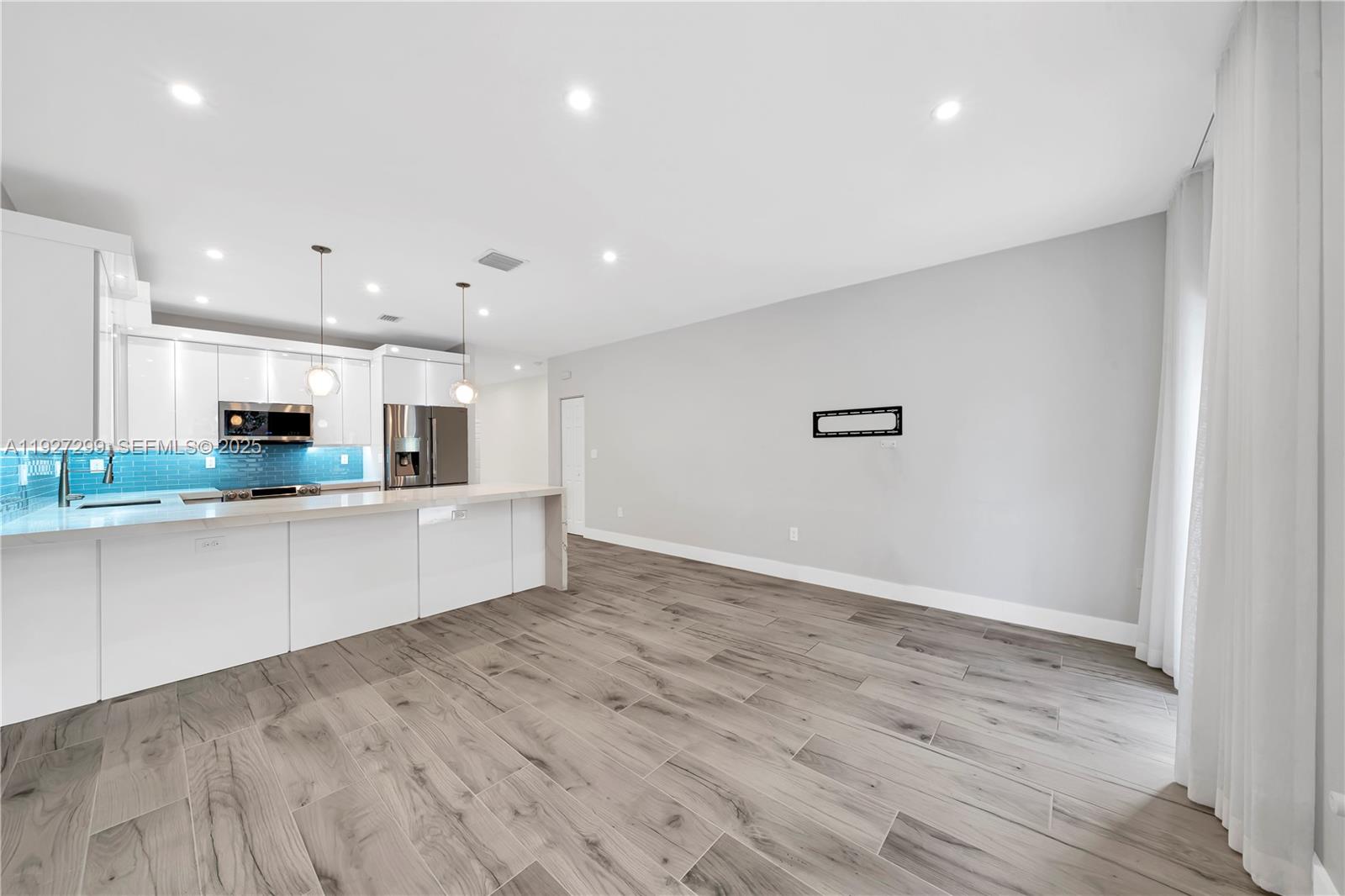11448 Southwest 151st Path Miami, FL 33196 - Photo 16 of 35 a large kitchen with stainless steel appliances granite countertop a large counter top and a wooden floor