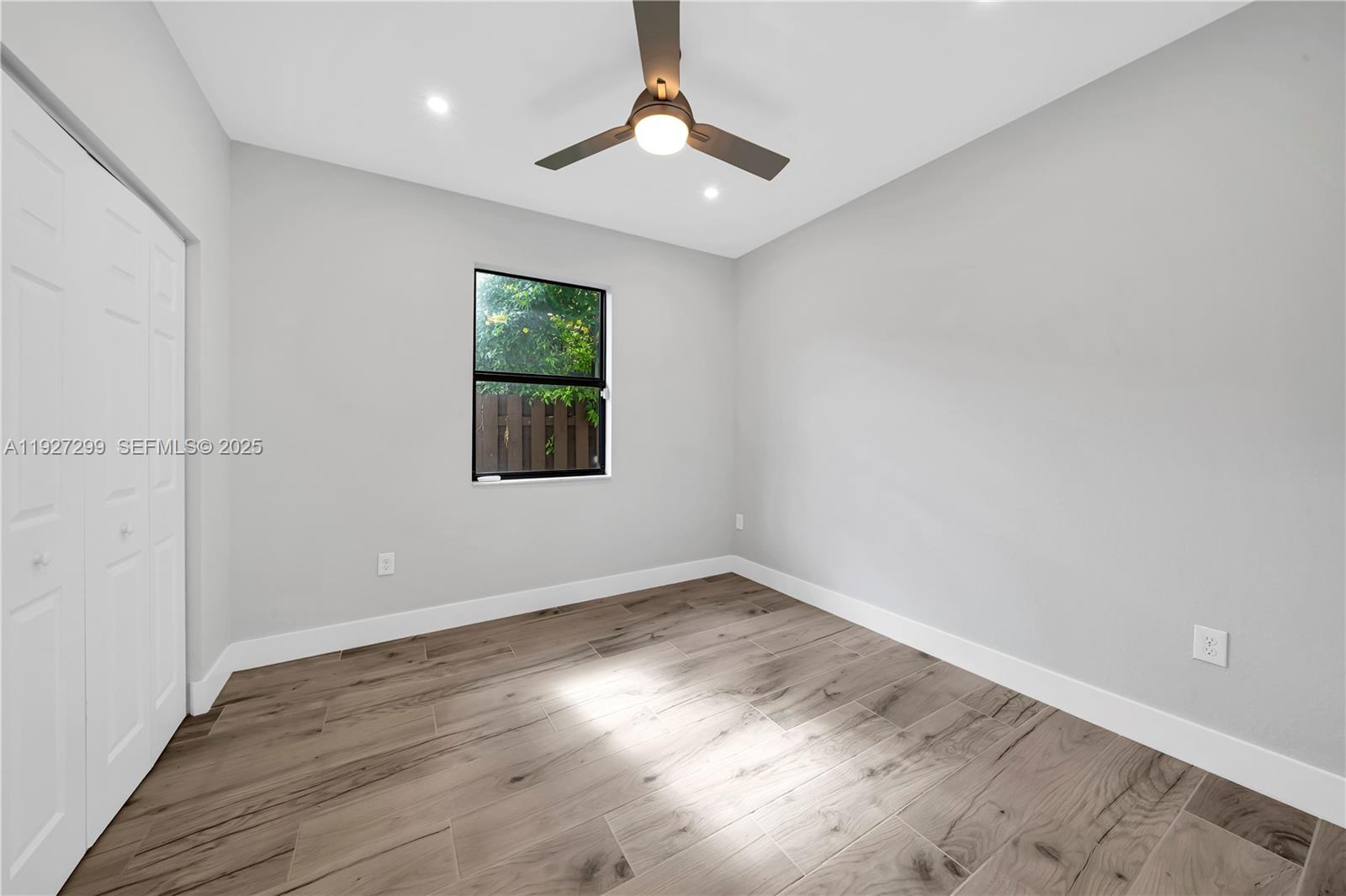 11448 Southwest 151st Path Miami, FL 33196 - Photo 18 of 35 wooden floor in an empty room with a window