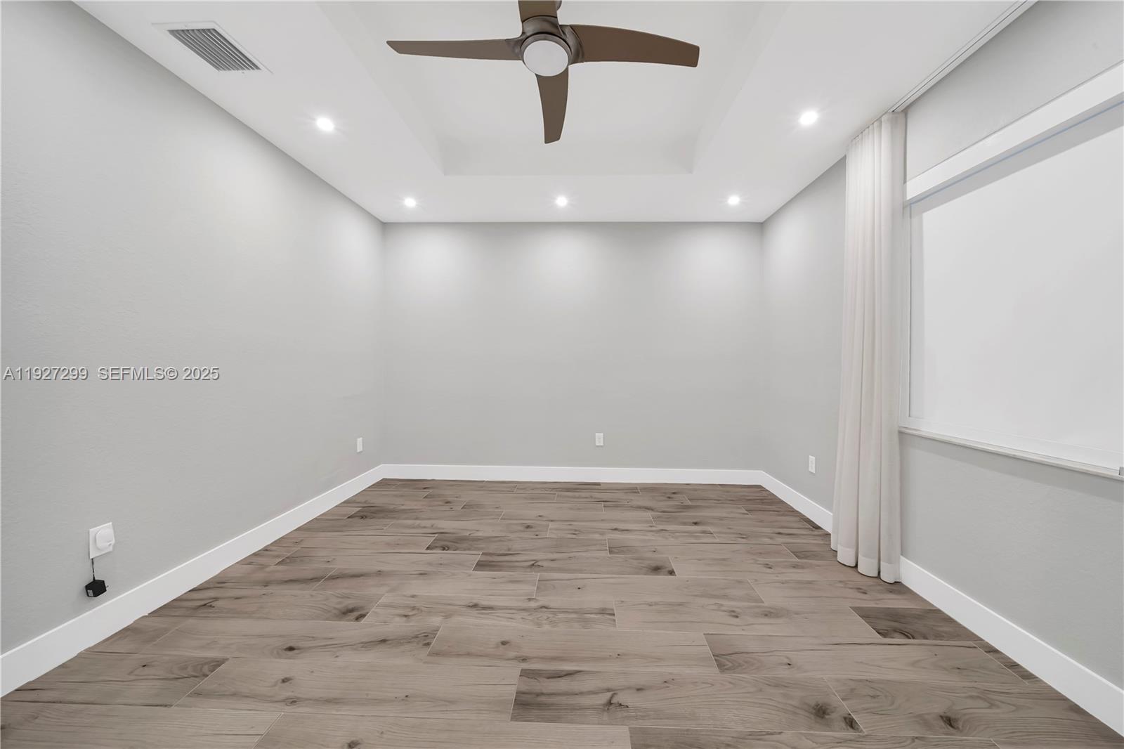 11448 Southwest 151st Path Miami, FL 33196 - Photo 21 of 35 an empty room with a ceiling fan and wooden floor