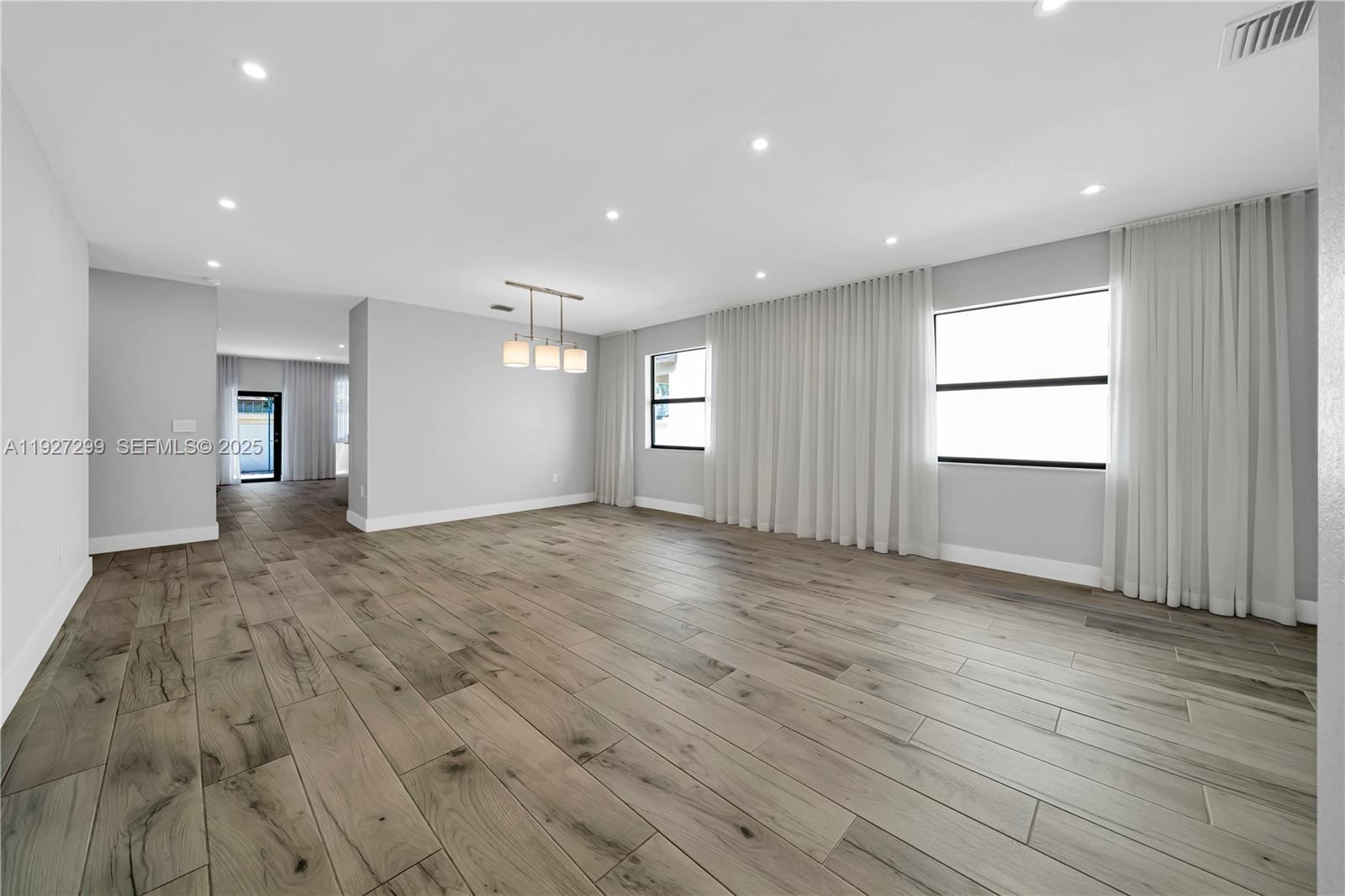 11448 Southwest 151st Path Miami, FL 33196 - Photo 10 of 35 an empty room with wooden floor and windows