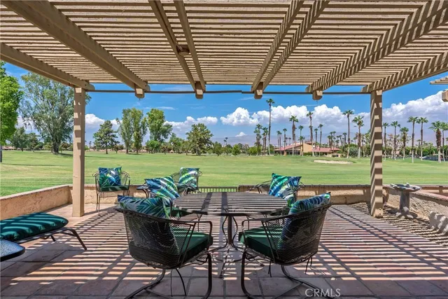 a view of a patio with table and chairs potted plants and palm tree