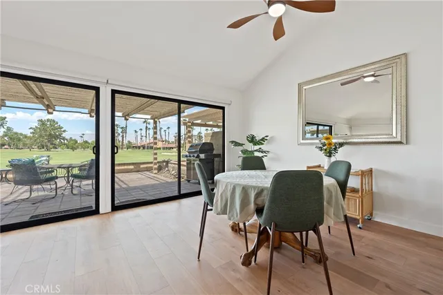 a dining room with furniture potted plants and wooden floor