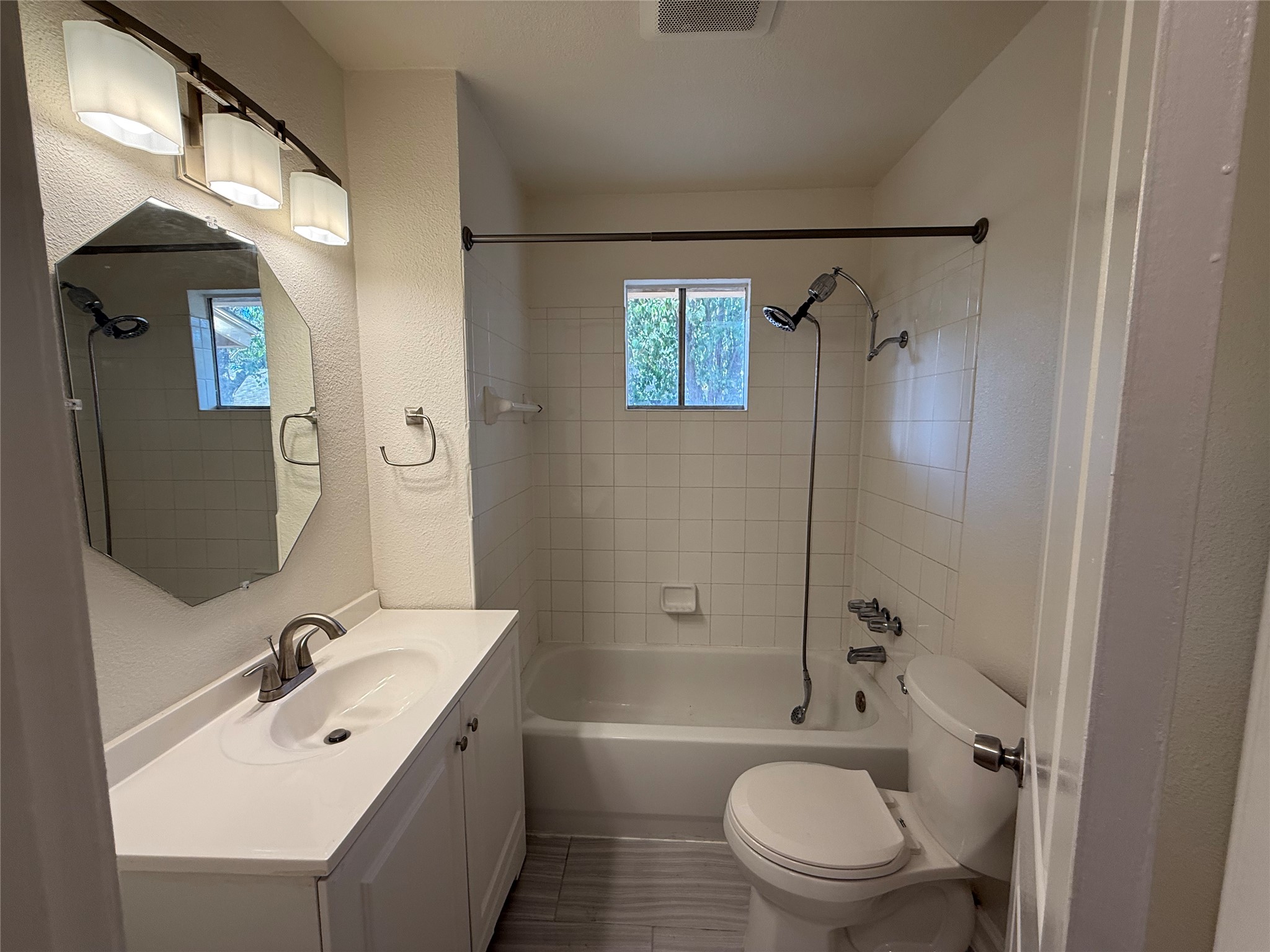 6710 Circle S Road, Unit B Austin, TX 78745 - Photo 7 of 14 a bathroom with a bathtub shower sink vanity mirror and toilet
