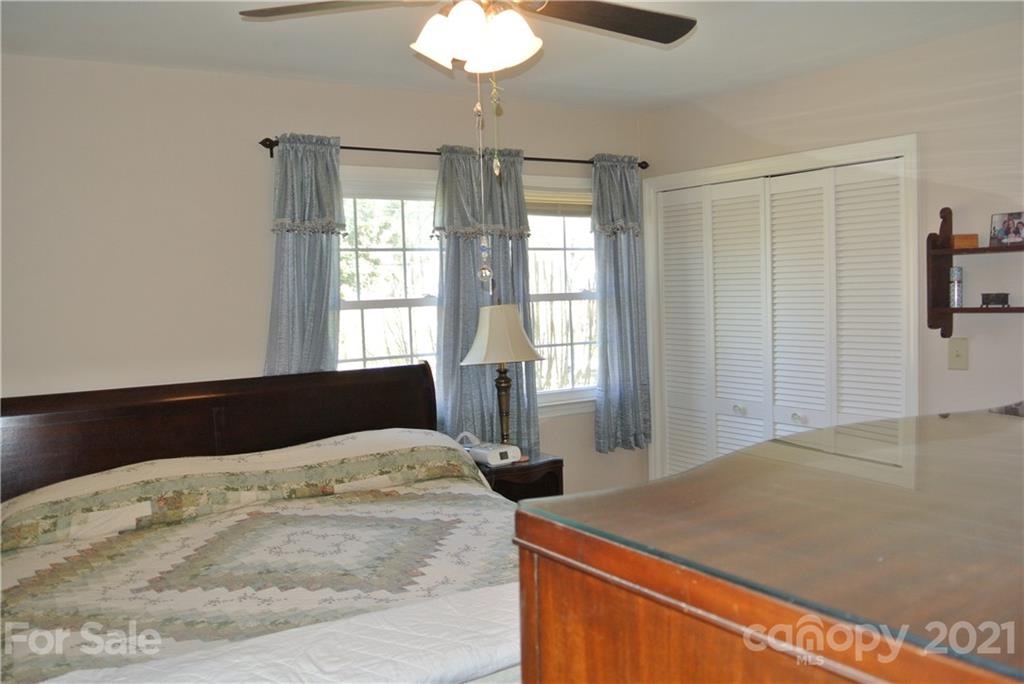 173 Tanner Street Rutherfordton, NC 28139 - Photo 16 of 25 a bedroom with a large bed and a chandelier