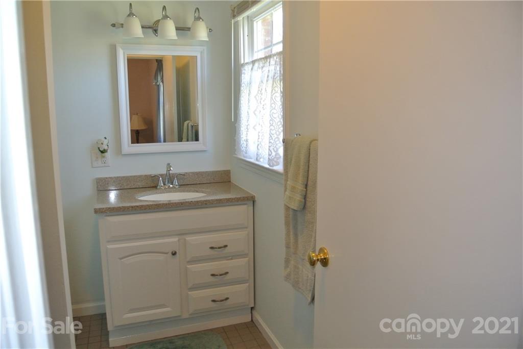 173 Tanner Street Rutherfordton, NC 28139 - Photo 18 of 25 a bathroom with a sink a mirror and a window