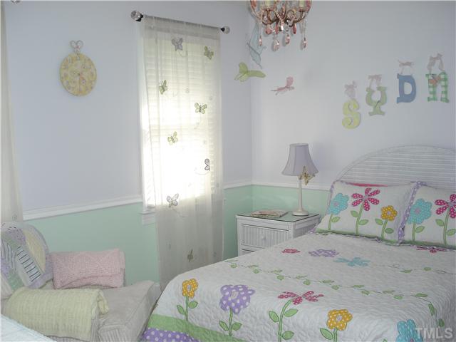 6836 Cool Pond Road Raleigh, NC 27613 - Photo 7 of 12 a bedroom with a bed and a table in it