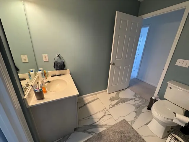 a bathroom with a sink and mirror with toilet