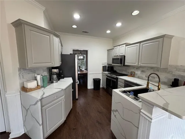 a kitchen with white cabinets and stainless steel appliances