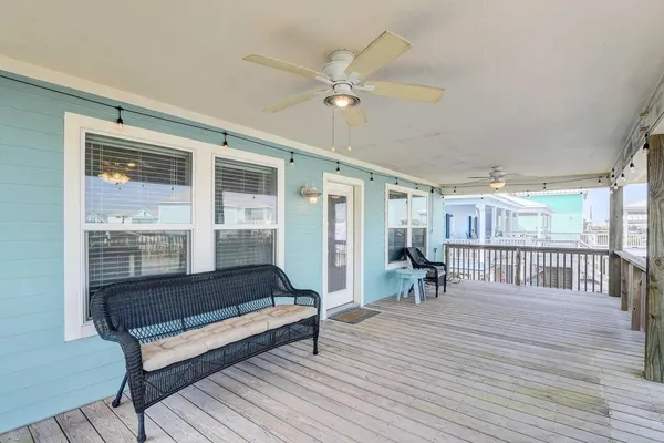 a view of a house with wooden deck and furniture