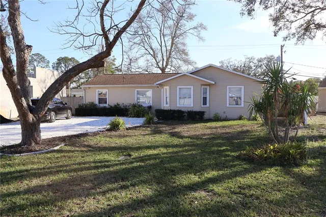 a front view of a house with a garden and trees