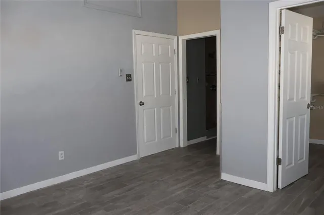 an empty room with wooden floor and closet