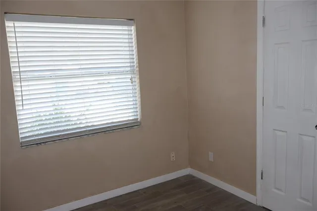 a view of a small space with wooden floor and a window