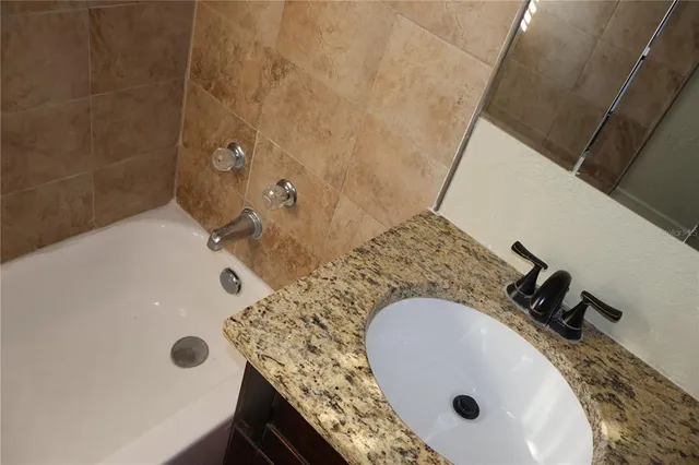 a bathroom with a tub sink and mirror