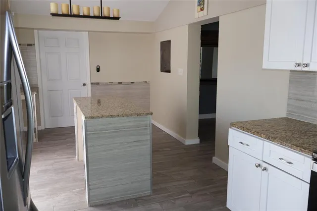 an empty room with wooden floor and cabinets