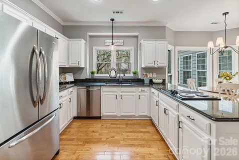 a kitchen with granite countertop a sink stainless steel appliances and window