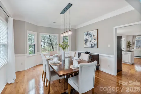 a dining room with furniture a chandelier and wooden floor