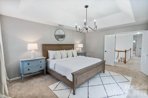 a bedroom with a bed and a chandelier