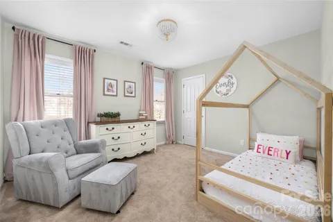 a spacious bedroom with a bed and a dresser