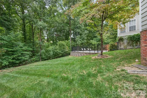 an aerial view of a house with swimming pool and large trees