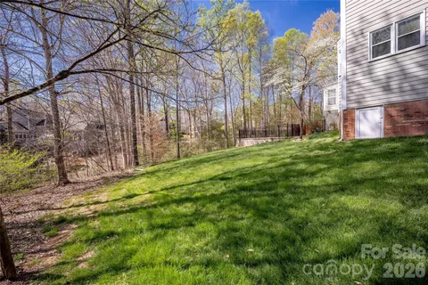 an aerial view of a house with a yard and a large tree