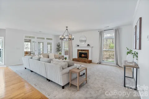 a living room with furniture a fireplace and a chandelier