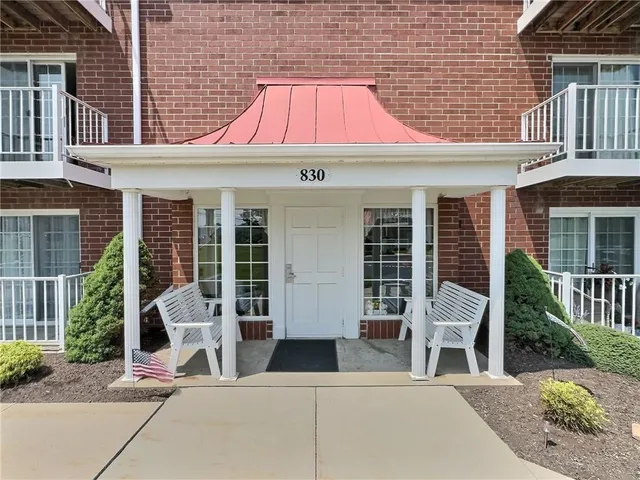 a front view of a house with garden and seating area