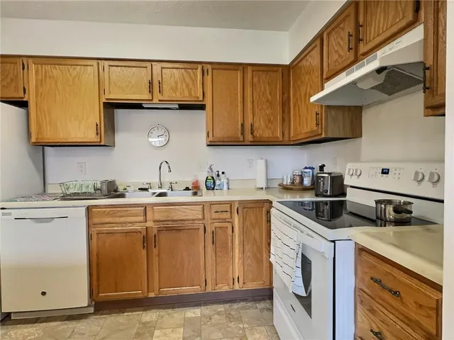 a kitchen with cabinets appliances a sink and a counter space