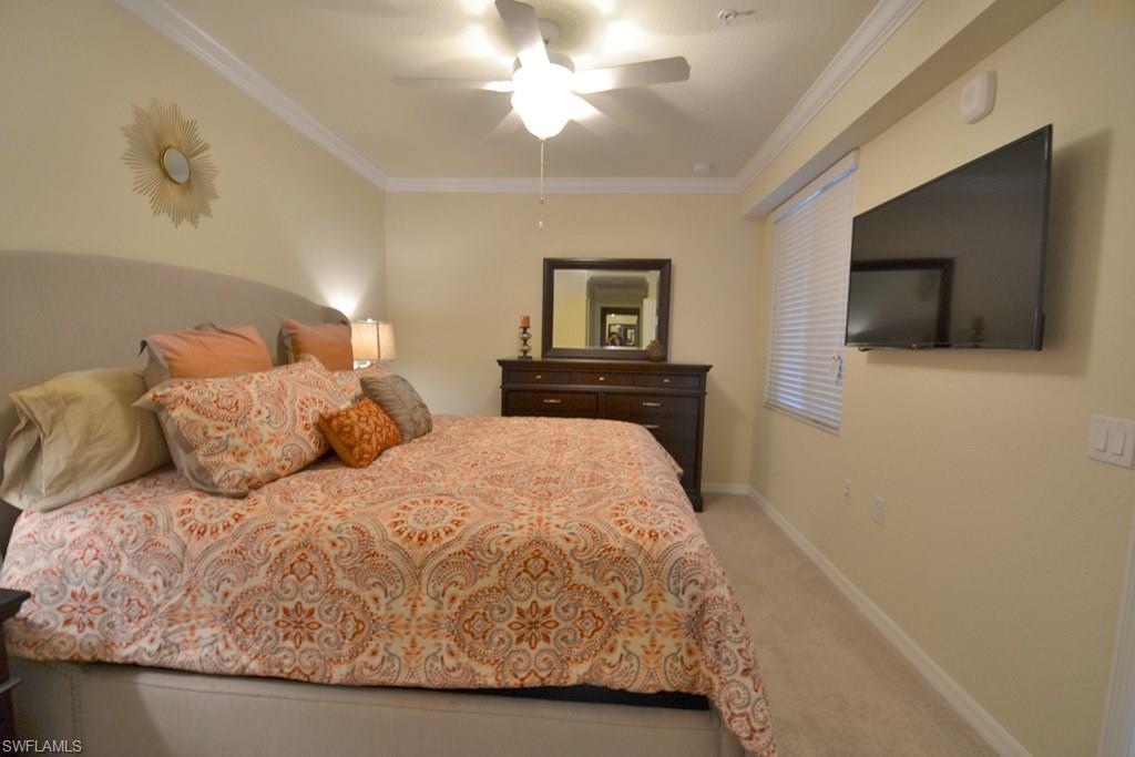 9560 Trevi Court, Unit 4816 Naples, FL 34113 - Photo 12 of 31 a bedroom with a bed and a flat screen tv
