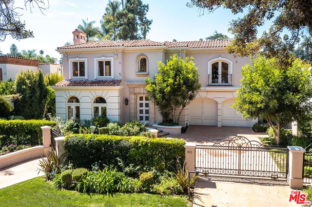 a front view of a house with a yard and potted plants