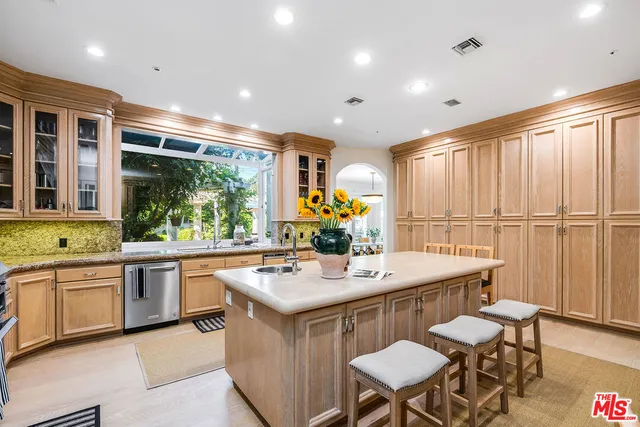 a kitchen with stainless steel appliances granite countertop table chairs sink and cabinets