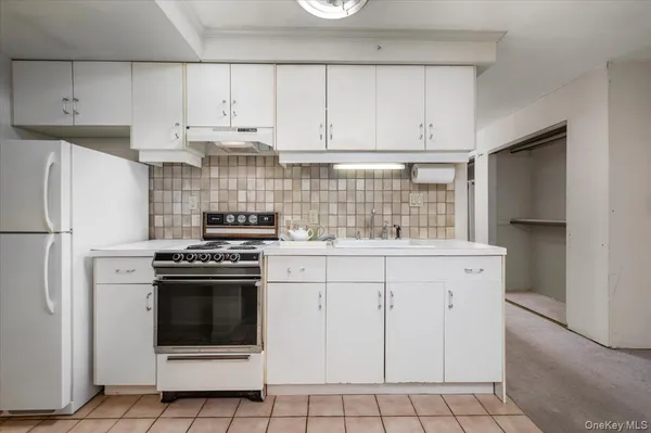 a kitchen with white cabinets and white appliances