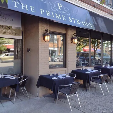 a front view of a building with parking area and a ceiling fan