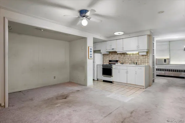 a view of a kitchen with a sink and dishwasher a refrigerator with white cabinets