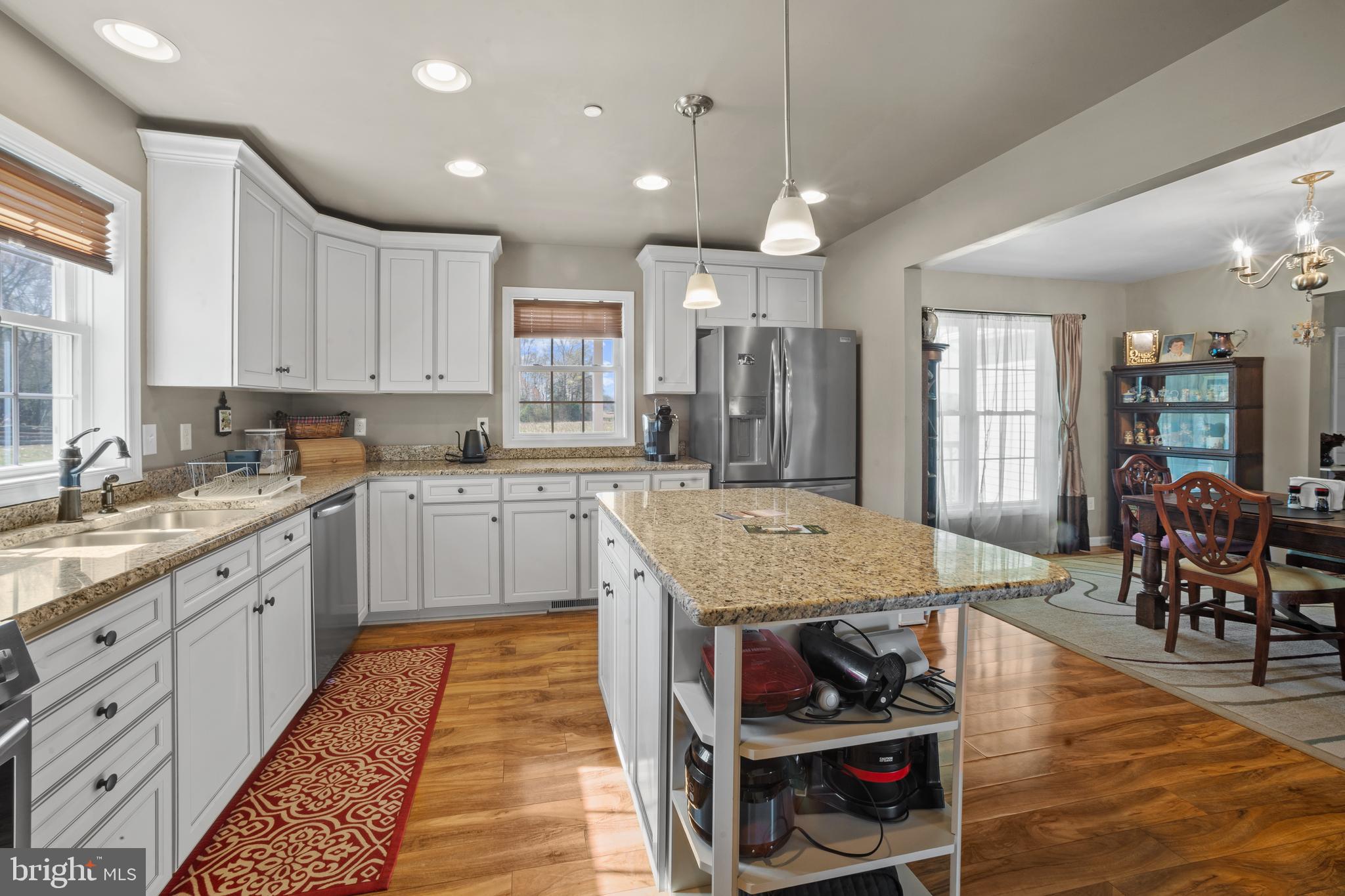 26268 Baker Road Denton, MD 21629 - Photo 15 of 55 a kitchen with stainless steel appliances granite countertop a stove top oven a sink dishwasher and white cabinets with wooden floor