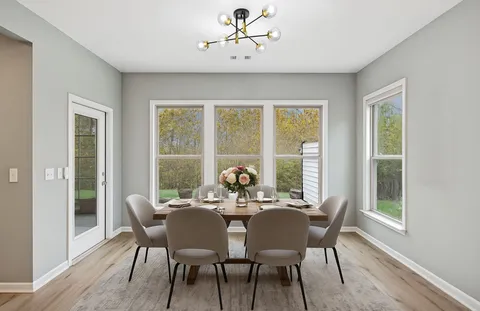 a large white kitchen with wooden floors and a fireplace