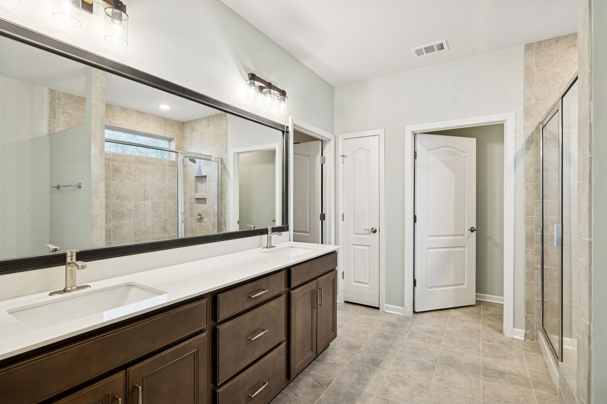 7027 Hickman Way Spring Hill, TN 37174 - Photo 30 of 61 a bathroom with a double vanity sink and mirror