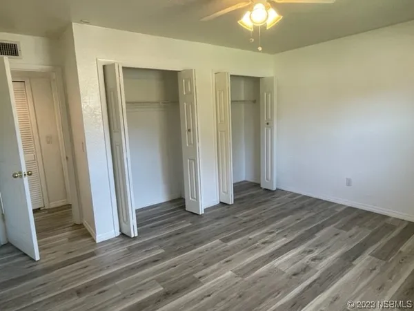 an empty room with wooden floor and a bathroom