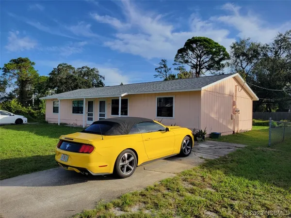 a car parked in front of a house with a garden