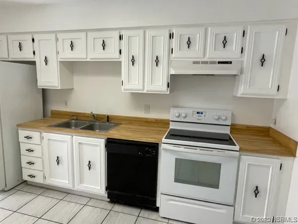 a kitchen with granite countertop white cabinets and black appliances