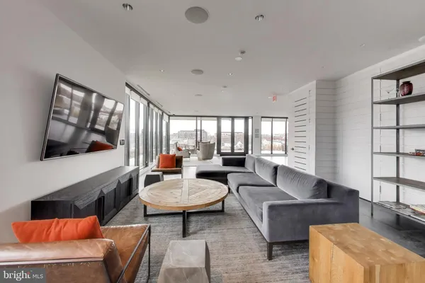 a living room with furniture and floor to ceiling windows