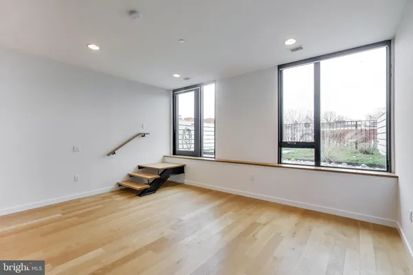 a big room with wooden floor and windows