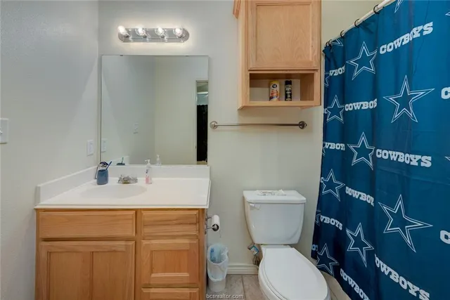 a bathroom with a granite countertop toilet sink and mirror