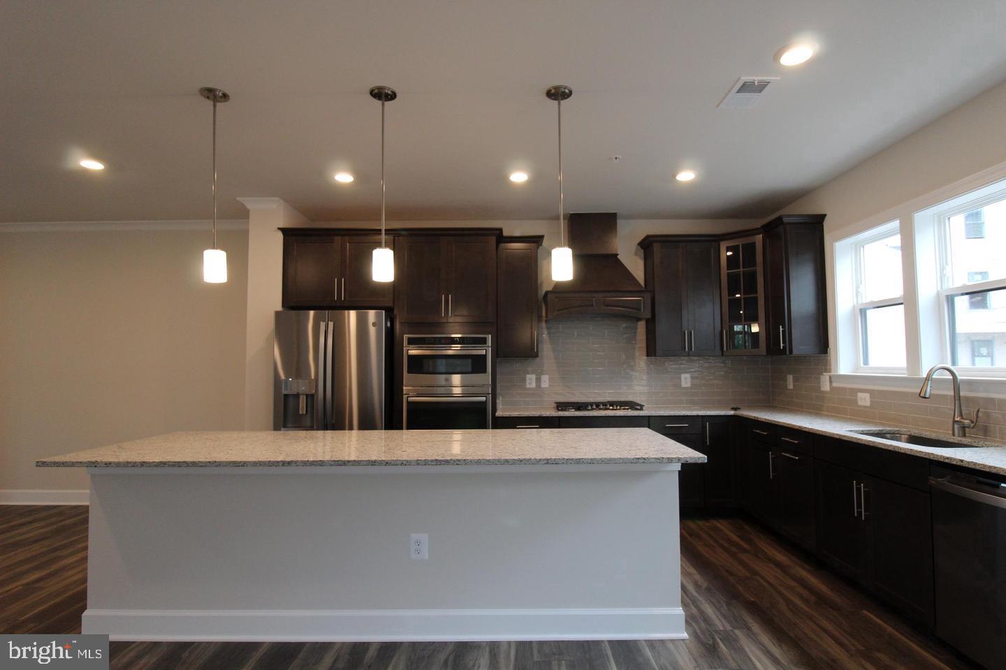 22466 Foundation Drive Ashburn, VA 20148 - Photo 6 of 21 a large kitchen with a large counter top a sink a window and stainless steel appliances