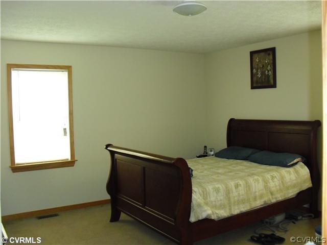 1901 Coxtown Road Crozier, VA 23039 - Photo 6 of 8 a bed sitting in a bedroom next to a small window