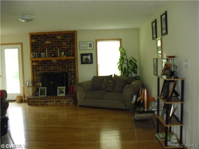 1901 Coxtown Road Crozier, VA 23039 - Photo 7 of 8 a living room with furniture a fireplace and a flat screen tv